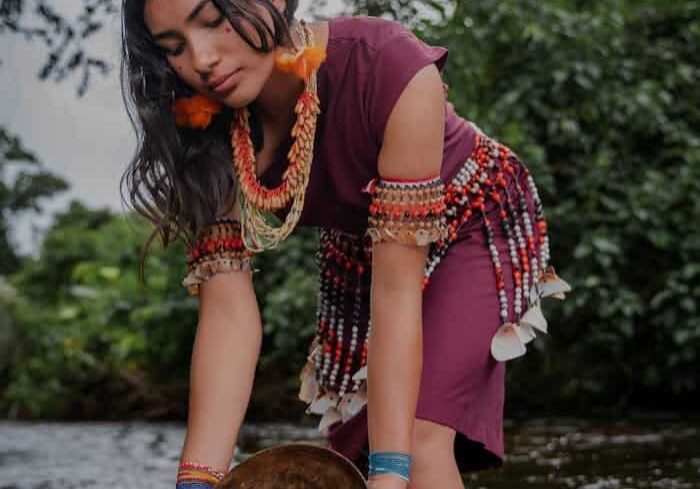 Woman in Traditional Clothing Standing with Bowl in River